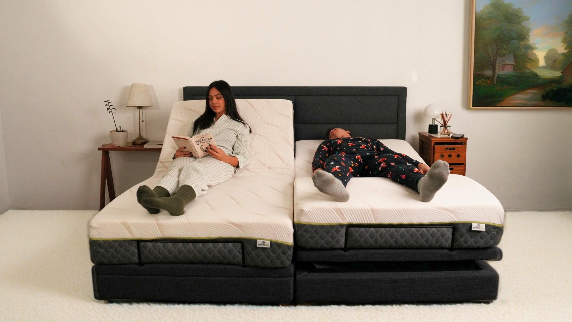 Two people lying on a split adjustable bed in a bedroom setting.